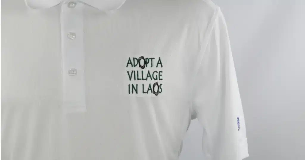 Polo shirt displayed with Adopt A Village In Laos embroidery